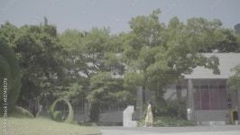 건물앞을 걷는 여성1(슬로우모션+원피스+여름+도시+바람+나무+햇빛+조형물+조경) Stock 비디오 | Adobe Stock 건물앞을 걷는 여성1... 
