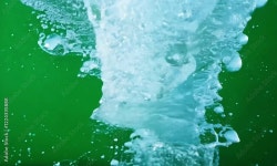 close-up of water splashing with vibrant green bubbles and droplets, capturing fluid motion and serene underwater textures in a... 