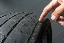 Finger pointing to damage on tire tread. Tire tread problems by tire pressure improper, Wheel alignment Stock Photo | Adobe Stock... 