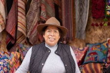 Portrait of a Peruvian woman in an alpaca wool handicraft shop, with ruanas and cushions in the background. Stock Photo | Adobe... 