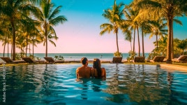 Couple enjoying beach vacation holidays at tropical resort with swimming pool and coconut palm trees near the coast with... 