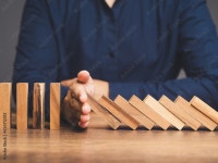 Business professionals stop the crisis domino effect, safeguarding against business collapse. Stock Photo | Adobe Stock Business... 