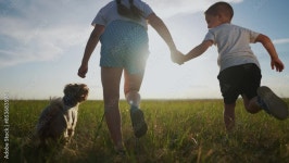 Family happy pet concept. A mom and her dog are running with their child. A mom and her son are running lifestyle with their dog.... 