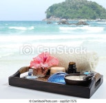 Sea spa. Toiletries with flower and candles on a tray near the sea. | CanStock