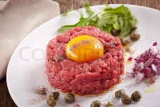 Fresh beef tartar with egg on white ... | Stock image | Colourbox