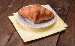 Croissant on a white plate on the table | Stock image | Colourbox