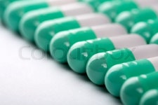 Closeup of green-white pills in a row | Stock image | Colourbox