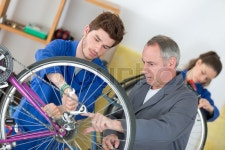 Apprentice looking a wheel of a bike | Stock image | Colourbox