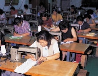 재봉틀에 집중하고 있는 사람들