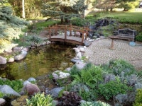디딤스톤브릿지 | This simple Asian style footbridge leads from a circular patio to a small trail through the rest of the garden over a small pond...