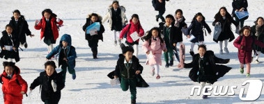 (서울=뉴스1) 오대일 기자 = 21일 오전 서울 성북구 성신초등학교에서 겨울방학을 맞은 1학년 어린이들이 방학식을 마친 뒤 환호성을... 