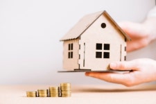 Crop hand holding house near coins  Photo | Free Download