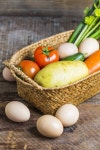 Eggs next to a basket with vegetables  Photo | Free Download