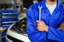 Mechanic with arms crossed holding spanner  Photo | Free Download