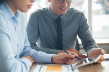 Smiling Asian business people discussing data  Photo | Free Download