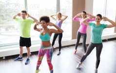 유토이미지 | fitness, sport, dance and lifestyle concept - group of smiling people with coach dancing zumba in gym or studio