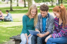 유토이미지 | College students using tablet PC in park