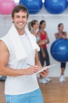 유토이미지 | Trainer holding clipboard with fitness class in background