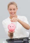 Businesswoman saving money in a piggibank | 유토이미지 | 상세페이지 | 베이직샵 | 사진 | 16997326