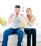 유토이미지 | Shocked man sitting on the sofa with his girlfriend