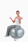 Portrait of a fit woman working out with dumbbells and a ball | 유토이미지 | 상세페이지 | 베이직샵 | 사진 | 17274374