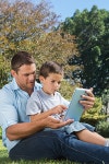 Dad and son playing with a tablet pc in a park | 유토이미지 | 상세페이지 | 베이직샵 | 17583208
