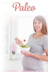유토이미지 | Paleo against charming pregnant woman eating a cherry tomato while standing
