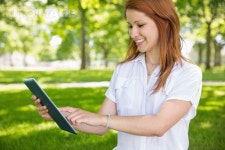 유토이미지 | Pretty redhead using her tablet pc in the park 유토이미지 | Pretty redhead using her tablet pc in the park 