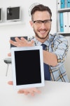 유토이미지 | Happy casual businessman showing tablet pc 유토이미지 | Happy casual businessman showing tablet pc 