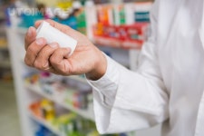 유토이미지 | Pharmacist holding and looking at medicine in the pharmacy
