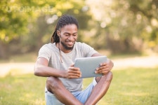 유토이미지 | Handsome hipster using his tablet pc on a sunny day