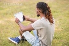 유토이미지 | Handsome hipster using his tablet pc on a sunny day