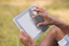 유토이미지 | Handsome hipster using his tablet pc on a sunny day