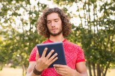 유토이미지 | Handsome hipster using tablet pc in the park on a sunny day