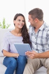 Happy couple with tablet PC sitting on sofa at home | 유토이미지 | 상세페이지 | 베이직샵 | 전체 | 19553711