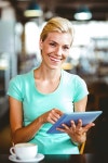 유토이미지 | Pretty blonde having a coffee using tablet pc at the coffee shop