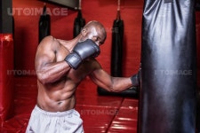 유토이미지 | Young Bodybuilder boxing a bag in the crossfit gym