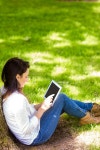 유토이미지 | Beautiful brunette using tablet pc in the park on a sunny day