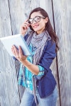 Happy hipster holding a tablet pc against a wooden wall | 유토이미지 | 상세페이지 | 베이직샵 | 사진 | 19915691