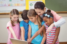 유토이미지 | Teacher and pupils looking at laptop at the elementary school