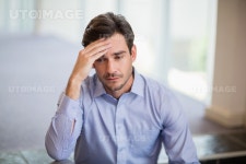 유토이미지 | Worried businessman with hand on head at conference centre