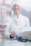 유토이미지 | Happy cheerful pharmacist chemist woman standing in pharmacy drugstore