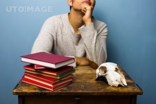 유토이미지 | Man with books and animal skull