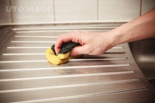 유토이미지 | The hand of a young woman is cleaning around the kitchen sink