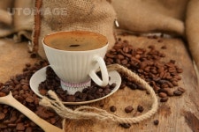 유토이미지 | Roasted coffee beans with cup on jute hessian background