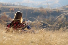 유토이미지 | Female hiker sitting on the ground using tablet pc outdoors