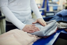 유토이미지 | Woman folding clean clothes in dry-cleaning workshop