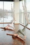 유토이미지 | Young thirsty woman in activewear drinking water or tea after training while sitting on mat against large window... 