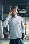Portrait of positive young fit Black man sweaty after intense training drinking fresh water and talking on phone | 유토이미지... 