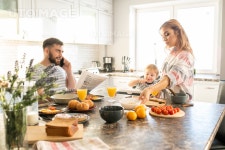 유토이미지 | Portrait of happy family enjoying breakfast in kitchen, young parents with cute baby sitting in kid chair at big... 